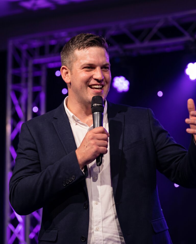 Spreker met microfoon op het podium tijdens een Vesto-infomoment